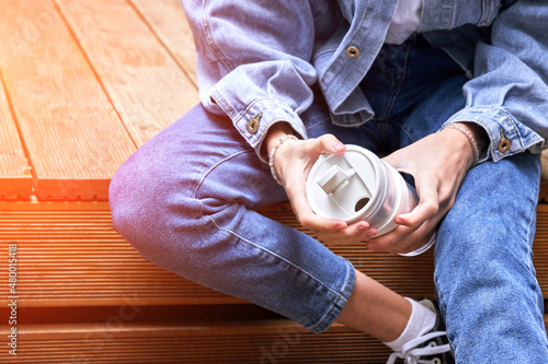 Pretty girl drink beverage outdoors. Buy takeaway coffee in own cup. Caucasian real people. Single female person. Alone. Ecology concept. Positive attractive human. Jeans dress. Sustainable lifestyle