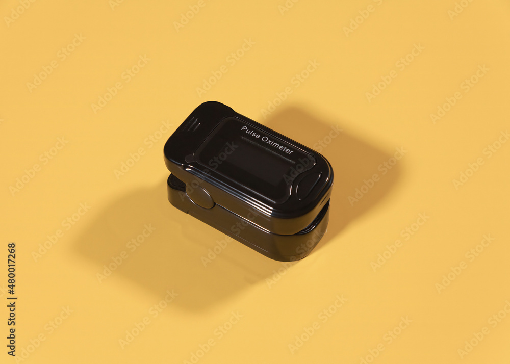 A small, portable pulse oximeter medical device (used to monitor a person's oxygen saturation by putting a finger into it). Black object isolated on a yellow background.
A small, portable pulse oximeter medical device (used to monitor a person's oxygen saturation by putting a finger into it). Black object isolated on a yellow background.