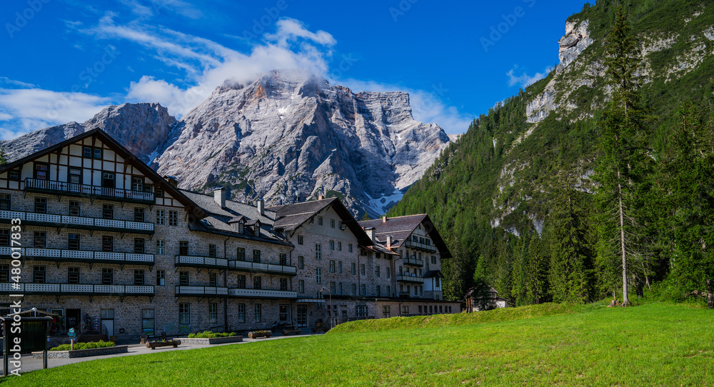 Travel in northern Italy. Beautiful town surrounded by Dolomite mountains. Small village with view of mountains and modern resort building.