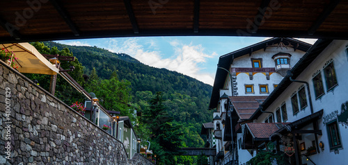 Traditional alpine houses with flowers on balcony. Colorful and picturesque village. Alpine village houses decorated with flowers street view. © eskstock