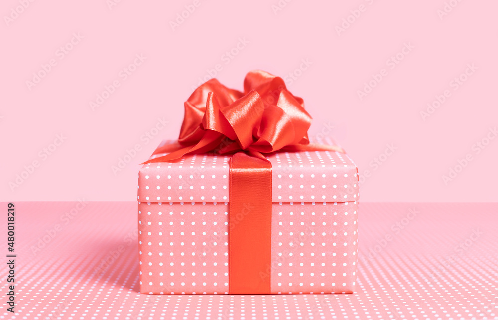 Pink gift box with a bow on a pink background. Close-up. Pink gift box with a bow on a pink background. Close-up.