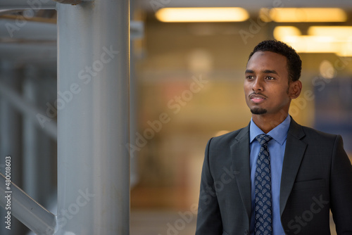 Black businessman wearing suit and looking through window