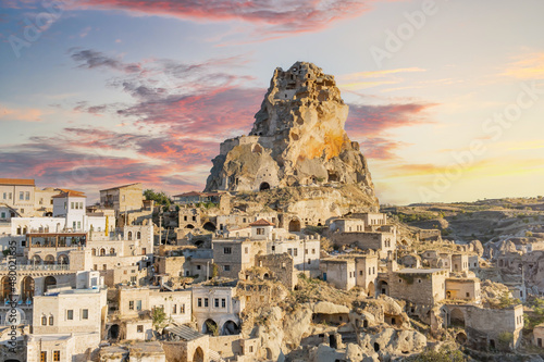 Ortahisar castle or central castle and fairy chimneys in Cappadocia, Turkey. Ortahisar Castle and traditional houses carved stone. Cave houses in fairy chimneys.