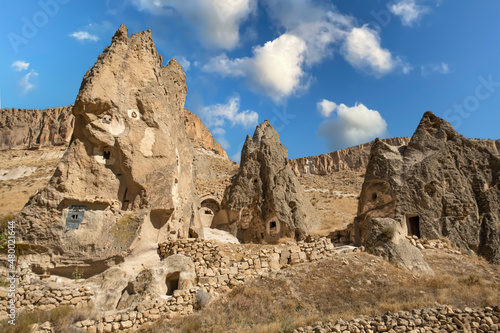 Fairy chimneys in Cappadocia valley, Turkey. Mushroom shaped rocks known as fairy chimneys in Cappadocia. Ancient churches and houses carved into the rocks.