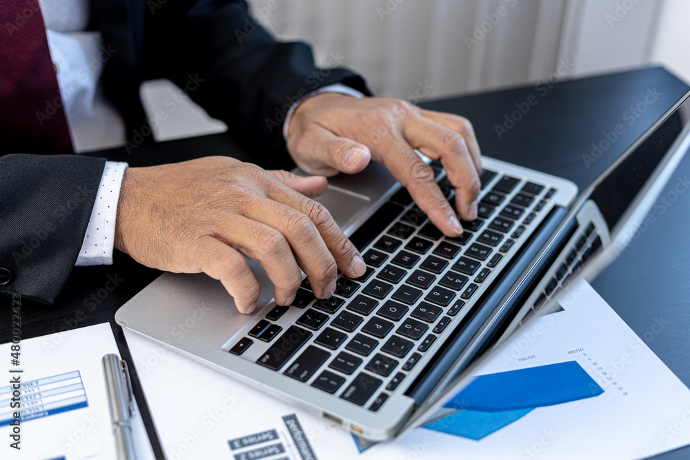Close-up A businessman working in a private room, He is typing on a laptop keyboard, He uses a messenger to chat with a partner. Concept of using technology in communication. Close-up A businessman working in a private room, He is typing on a laptop keyboard, He uses a messenger to chat with a partner. Concept of using technology in communication.