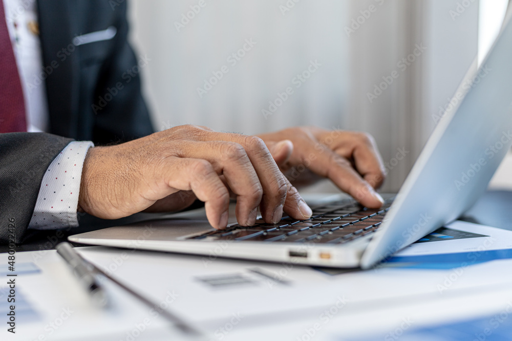 Close-up A businessman working in a private room, He is typing on a laptop keyboard, He uses a messenger to chat with a partner. Concept of using technology in communication. Close-up A businessman working in a private room, He is typing on a laptop keyboard, He uses a messenger to chat with a partner. Concept of using technology in communication.
