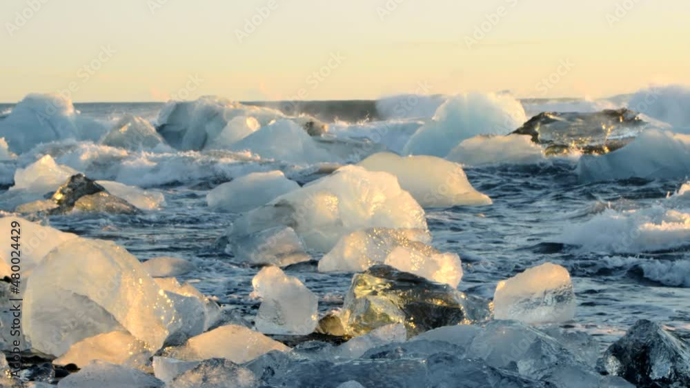 Icebergs floating and melting in Stormy Ocean. Climate Change Global Warming problem. Diamond Beach, Iceland. Icebergs floating and melting in Stormy Ocean. Climate Change Global Warming problem. Diamond Beach, Iceland.