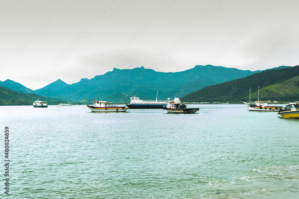 Boats on the beach with mountains in the background