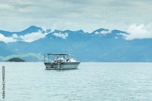 Boats on the beach with mountains in the background