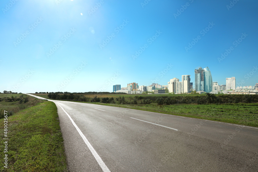 Empty asphalt road and beautiful view of cityscape on sunny day