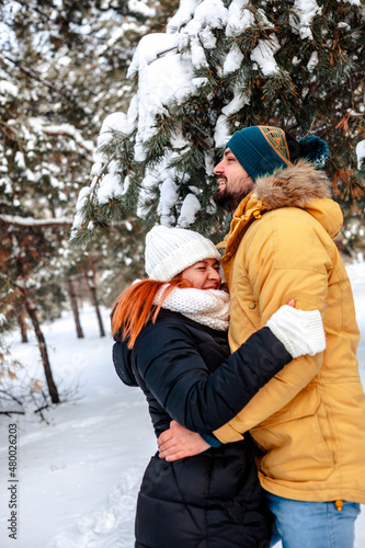 Photo of charming pretty marriage couple wear windbreakers embracing smiling having fun walking snowy weather outside park 