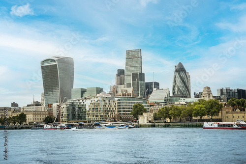Photography There are office buildings, skyscrapers, churches in the business against the background of blue sky and clouds, river Thames, district of London, UK