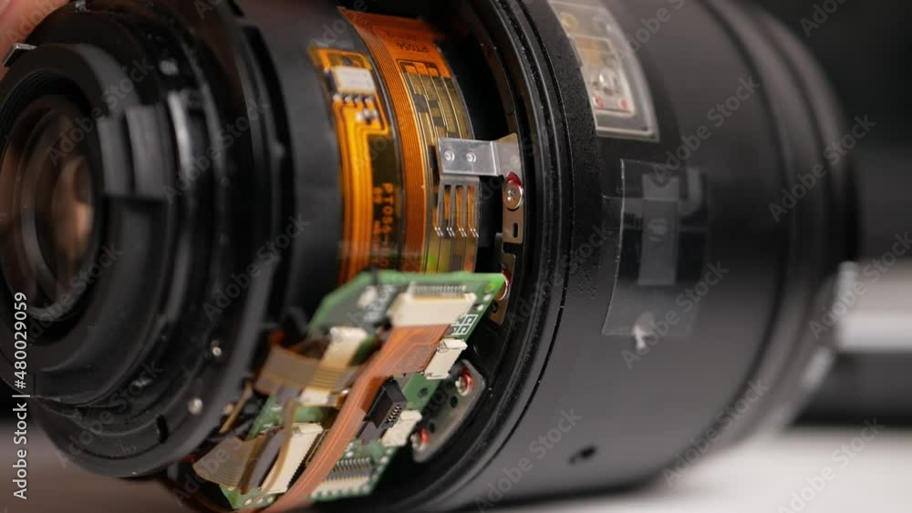 man repairs camera lens, autofocus motor, tools. naked lens man repairs camera lens, autofocus motor, tools. naked lens