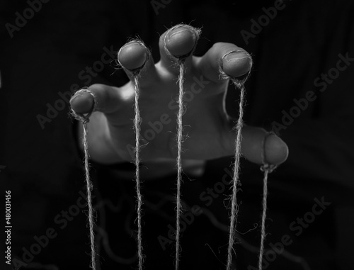 Manipulation concept. Hand of abuser manipulate with string.