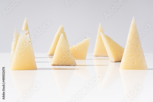 Trozos de queso manchego de oveja curado con tostadas de pan crujiente sobre una mesa blanca. Aperitivo español  photo