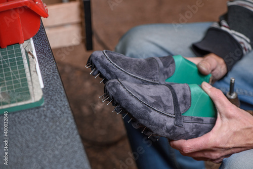 Obraz na płótnie Shoemaker holding pair of new handmade suede gray shoes in his hands, checking the quality of his work. Selective focus. w salonie