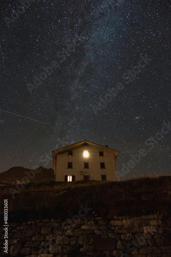 Night landscape with the Milky Way above a mountain house