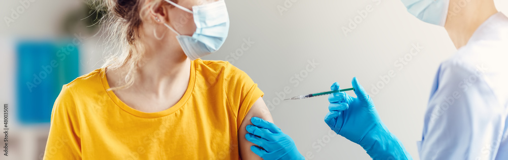 © candy1812 - Nurse giving vaccine syringe against Covid 19 to patient.