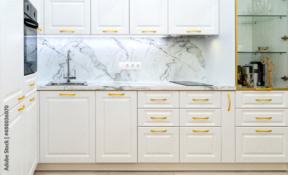 interior of neoclassical style white and gold wooden kitchen with island in luxury home interior of neoclassical style white and gold wooden kitchen with island in luxury home