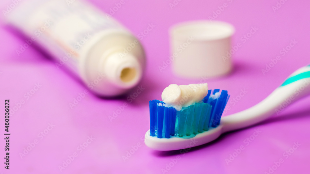 Toothbrush and tube of toothpaste on a purple background. Dental care Toothbrush and tube of toothpaste on a purple background. Dental care