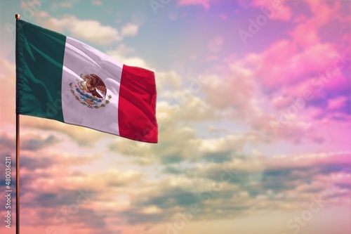 Fluttering Mexico flag mockup with the space for your content on colorful cloudy sky background.