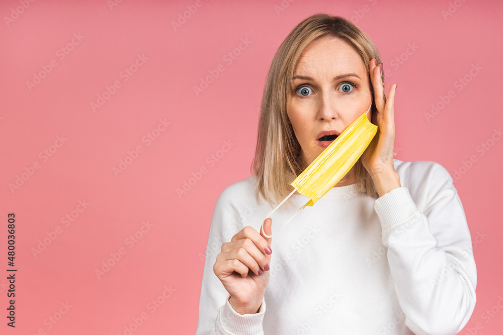 Close up portrait of cute pretty young blonde woman wearing protective mask making strategy stop personal pollution isolated over pink background. Coronavirus concept. Close up portrait of cute pretty young blonde woman wearing protective mask making strategy stop personal pollution isolated over pink background. Coronavirus concept.
