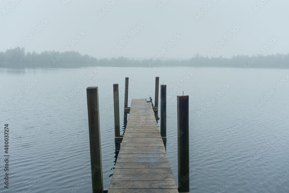 Naklejka premium Earlier foggy morning on the lake with the pier