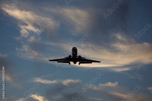 A private jet airliner is landing at sunset