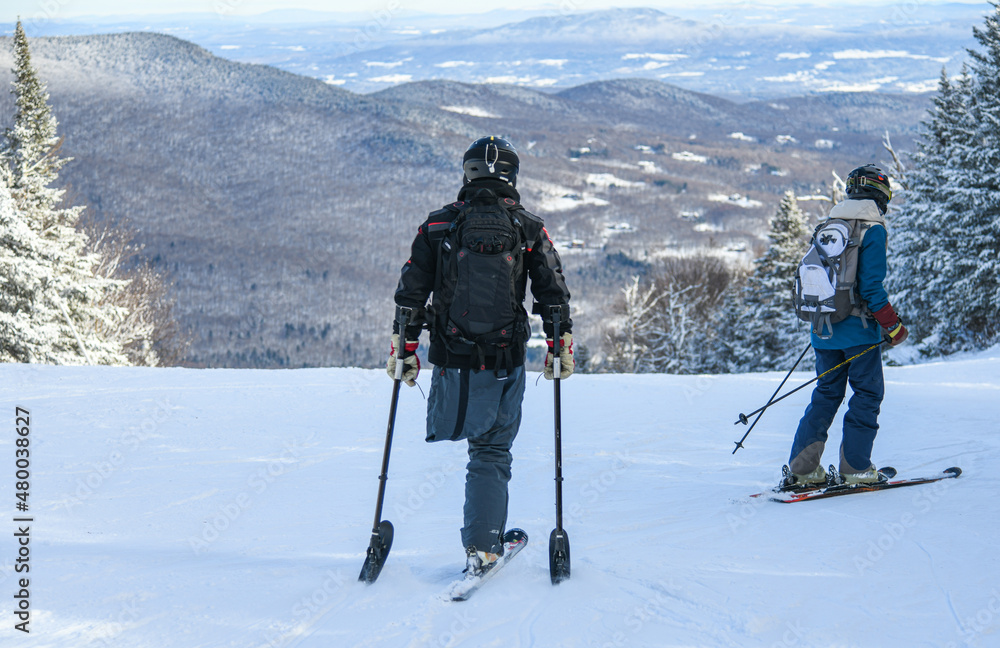 Adaptive Skiing with one leg : Disabled ski racer a three-tracker, or one-legged skier training kids how to ski at Stowe mountain resort Adaptive Skiing with one leg : Disabled ski racer a three-tracker, or one-legged skier training kids how to ski at Stowe mountain resort