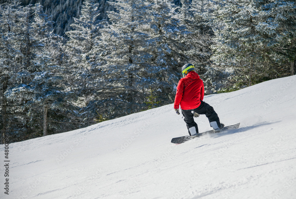 Dynamic photo of snowboarder in bright jacket downhill. Enjoying winter vacation snowboarding in the mountains on fresh powder snow slopes. Dynamic photo of snowboarder in bright jacket downhill. Enjoying winter vacation snowboarding in the mountains on fresh powder snow slopes.