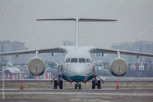 A twin-engine jet plane stands at the airport in the parking lot at winter  photo