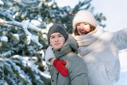 Guy and her girlfriend are walking in winter outdoors. Best friends. Brother and sister.