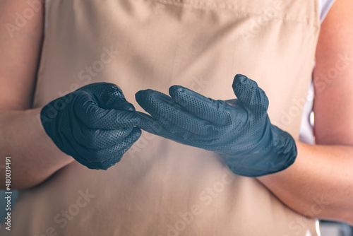 Cook in black gloves. Rules of hygiene during cooking. Confectioner in black latex gloves.