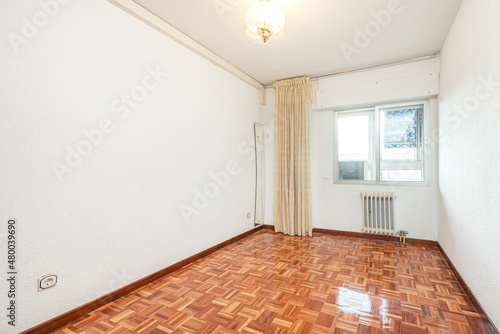 Room without furniture with curtains and mirror in one corner and shiny parquet