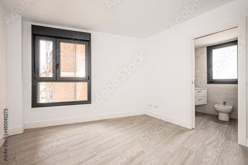 Foto Wall of an empty room with window and entrance to a toilet with porcelain stonew