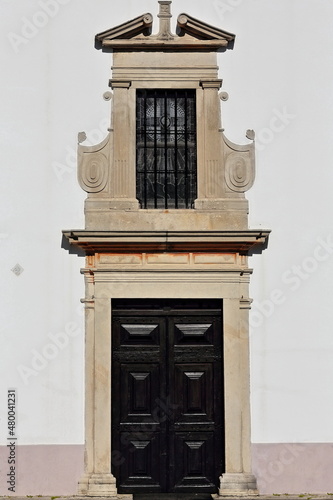 Rectangular wooden doorway-lattice window-whitewashed front facade-Saint Lawrence Church. Almancil parish-Algarve-Portugal-052