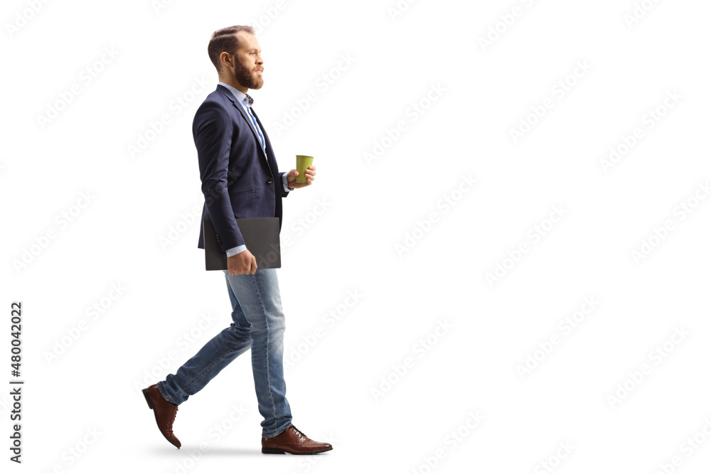 Full length profile shot of a young professional man walking with a takeaway coffee cup and a laptop - obrazy, fototapety, plakaty 