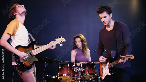young rock band performing together on stage.