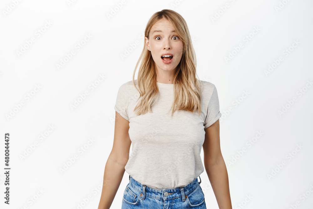 Portrait of blond girl looking surprised and amazed, saying wow, staring with thrilled face expression, white background Portrait of blond girl looking surprised and amazed, saying wow, staring with thrilled face expression, white background