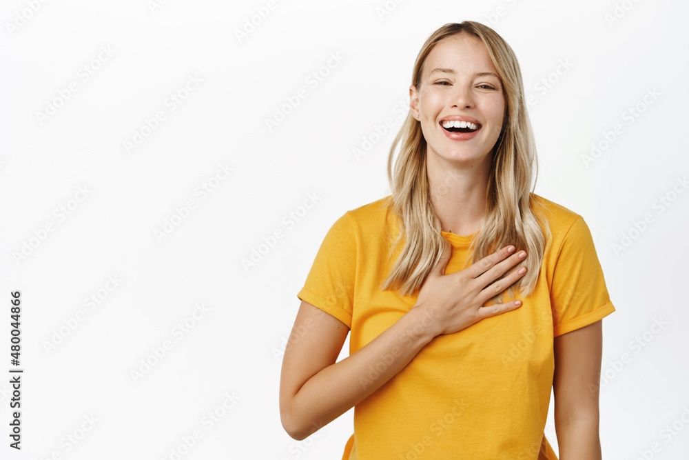 Smiling beautiful modern girl laughing, holding hand on heart appreciation gesture, grateful, say thank you, being pleased, receive compliment, white background Smiling beautiful modern girl laughing, holding hand on heart appreciation gesture, grateful, say thank you, being pleased, receive compliment, white background