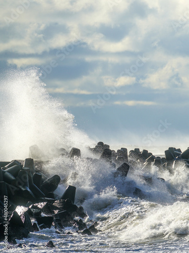 coastal storm in the baltic sea, big waves crash against the harbor breakwater