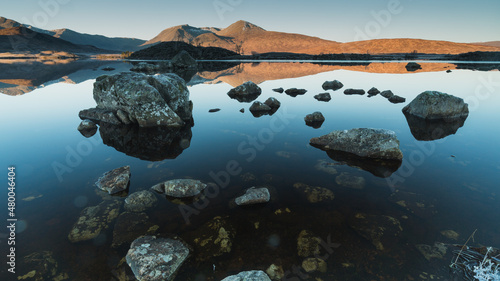 Mosaic of stones in a mountain lake at dawn.