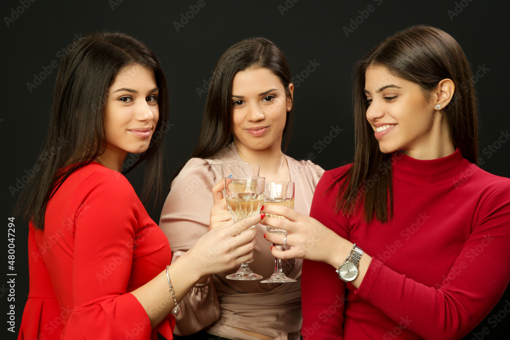 Three women clinking crystal wine glasses.