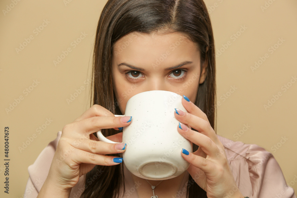 Studio shot of young brunette woman holds ceramic mug Studio shot of young brunette woman holds ceramic mug