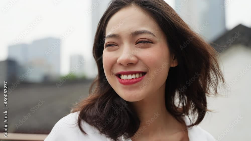 Slow motion happy young asian woman looking at camera smile in the Chengdu urban city background Slow motion happy young asian woman looking at camera smile in the Chengdu urban city background