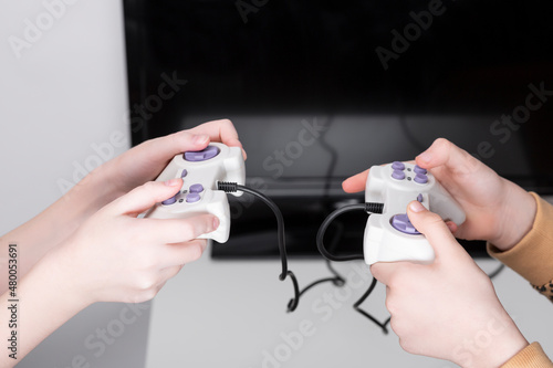 Wallpaper Mural Close up photo two little age girls, holding in hands two game joystick, trying hard to win game Torontodigital.ca