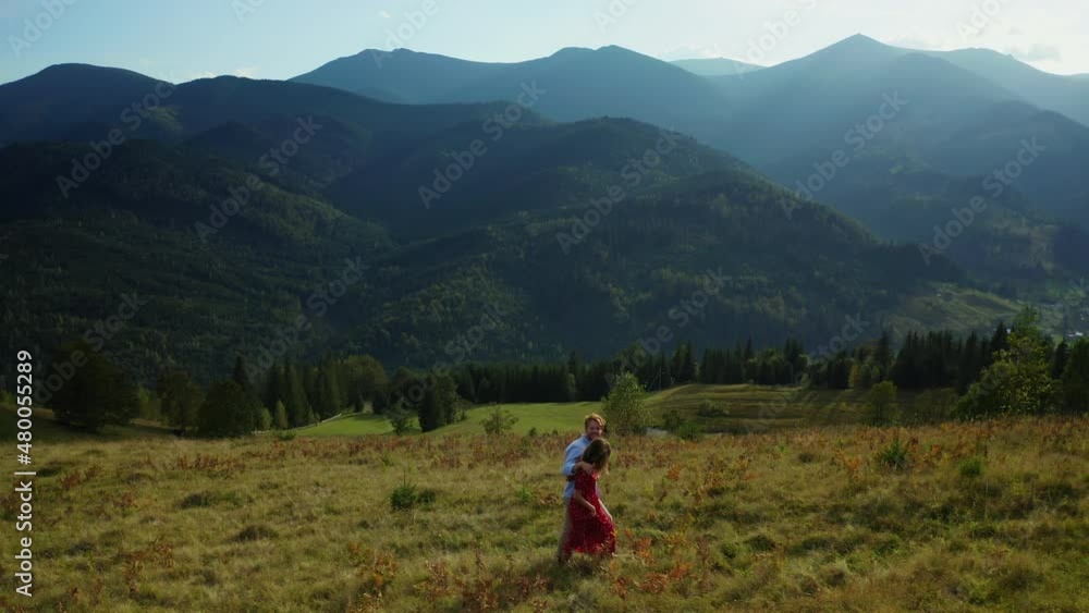 Lovers in mountains walking grass enjoying amazing landscape blue sky background Lovers in mountains walking grass enjoying amazing landscape blue sky background