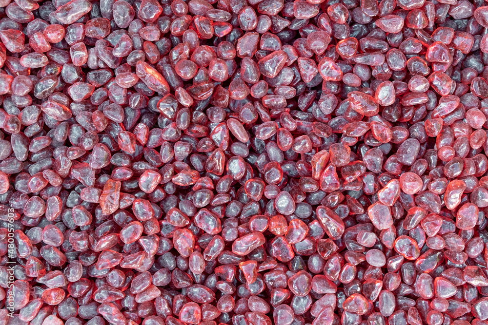 Red color texture of natural small mineral rock Garnet stones gemstone particles. Decorative Stone pebbles for coating in the garden. Extreme close up of heap top view Red color texture of natural small mineral rock Garnet stones gemstone particles. Decorative Stone pebbles for coating in the garden. Extreme close up of heap top view