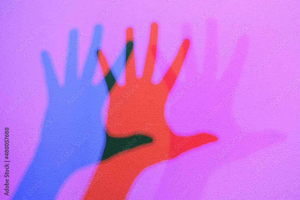 Colored shadows of a hand dancing to the music. Interactive exposition in science museum.
