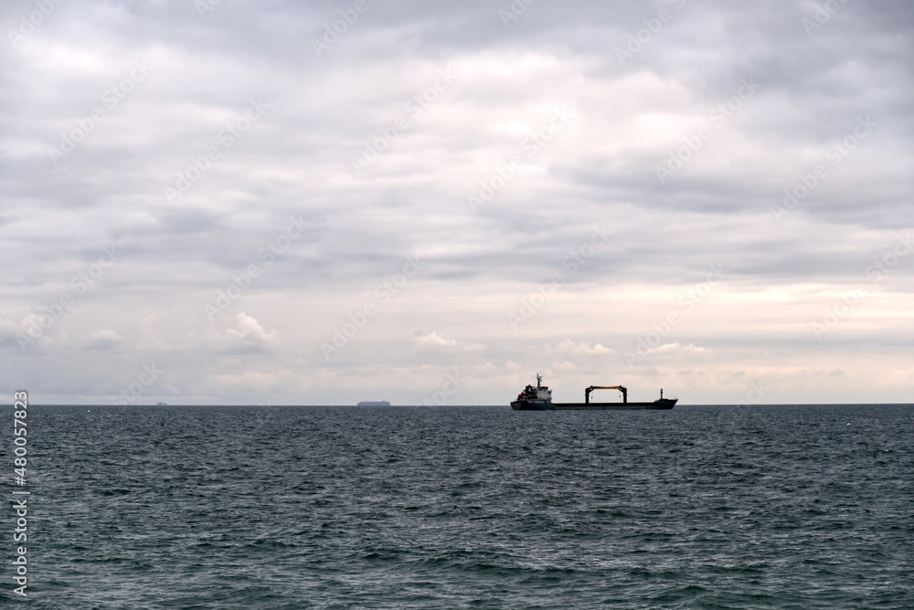 a cargo ship offshore on a cloudy day